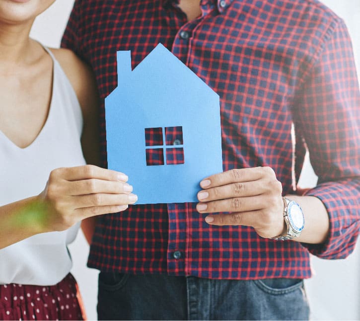 imagen de pareja con una hoja de papel con forma de una vivienda