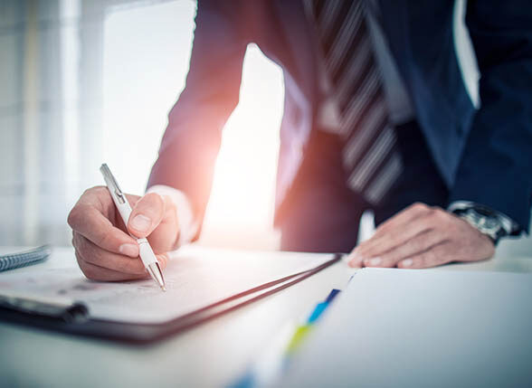 Business man signing contract document on office desk, making a deal.