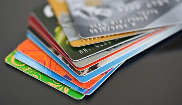 Sobre una superficie gris, varias tarjetas de crédito apiladas.