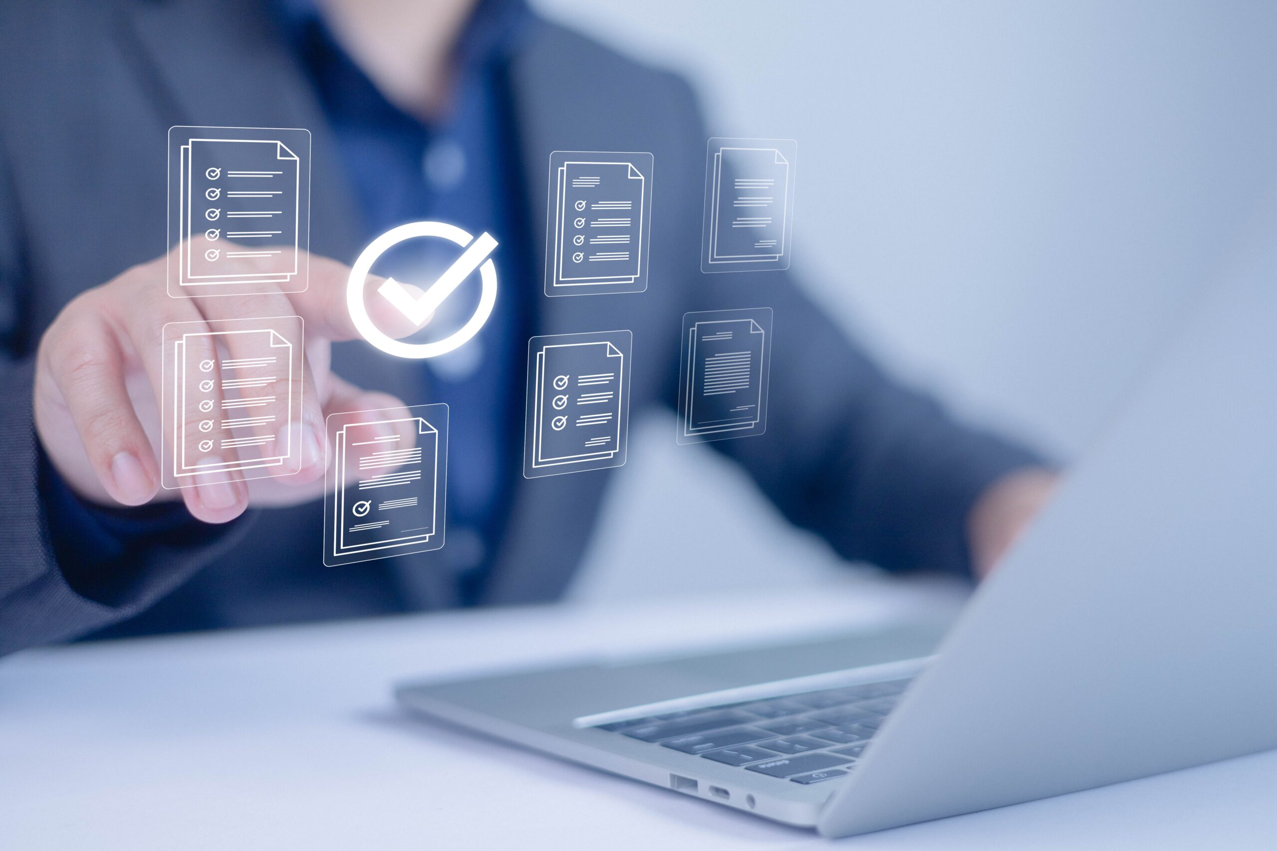 Hombre sentado en su escritorio frente a su laptop tocando con su mano un gráfico virtual.