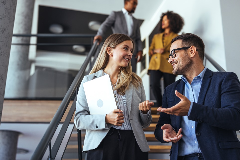 Colleagues Engaging in a Pleasant Discussion on Office Staircase