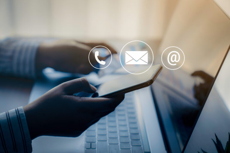 Persona ejecutiva usando el teléfono móvil, escribiendo en la computadora