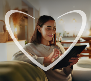Mujer feliz sentada en el sillón de su sala mientras realiza sus compras online de Black Friday.