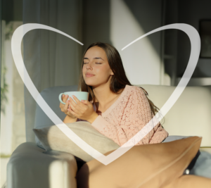 Mujer feliz sentada en el sillón de su sala mientras toma un té con el estrés bajo control