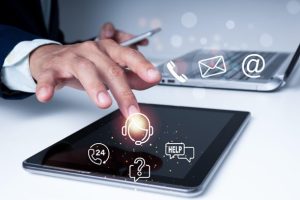 Mano sobre tablet mostrando varios canales de atención