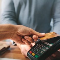 imagen de una mano sosteniendo tarjeta de crédito cuando se realiza pago en un datáfono